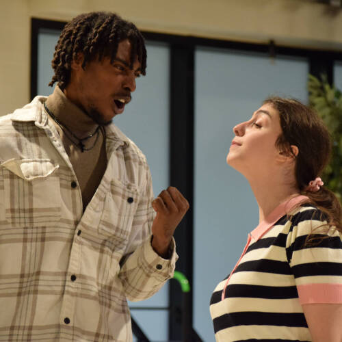 two student actors stand during a scene in a rehearsal for Midsummer Night's Dream